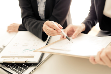 Business people discussing the charts and graphs showing the results of their successful teamworkの写真素材