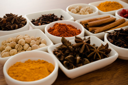 Wooden table of colorful spicesの写真素材