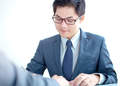 Two businessmen looking at report and having a discussion in office.の写真素材