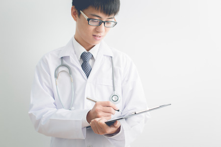 Close-up Of Male Doctor Filling The Medical Formの写真素材