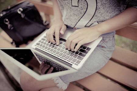 Young woman working on a laptop outdoorsの写真素材