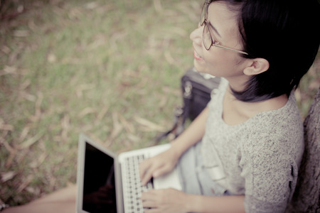 Young woman working on a laptop outdoorsの写真素材