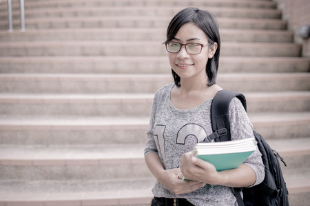 attractive female college student sitting on stairsの写真素材