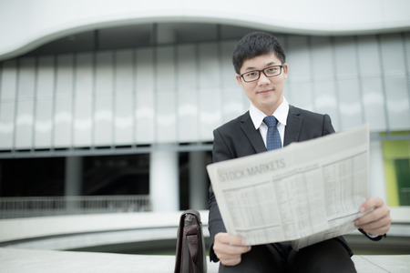 Handsome man reading a newspaperの写真素材