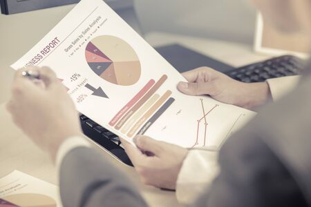 Business people discussing the charts and graphs showing the results of their successful teamworkの写真素材