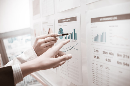 Businessman pointing to flip board with chart in officeの写真素材