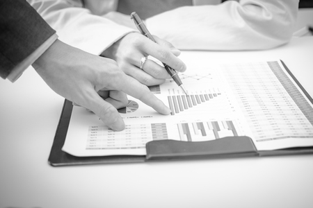 Business people discussing the charts and graphs showing the results of their successful teamworkの写真素材