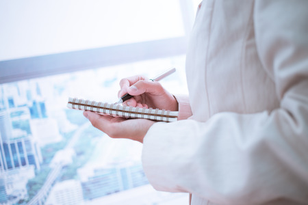 Woman taking notes during business meeting in the office.の写真素材