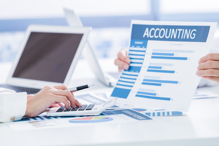 Business people discussing the charts and graphs showing the results of their successful teamworkの写真素材