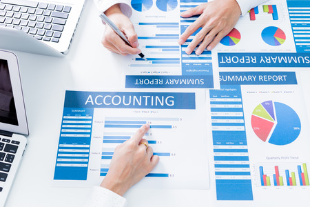 Business people discussing the charts and graphs showing the results of their successful teamworkの写真素材