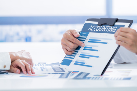 Business people discussing the charts and graphs showing the results of their successful teamworkの写真素材