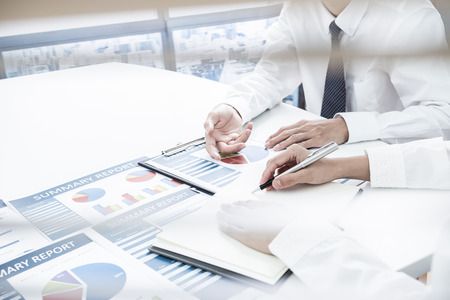 Business people discussing the charts and graphs showing the results of their successful teamworkの写真素材