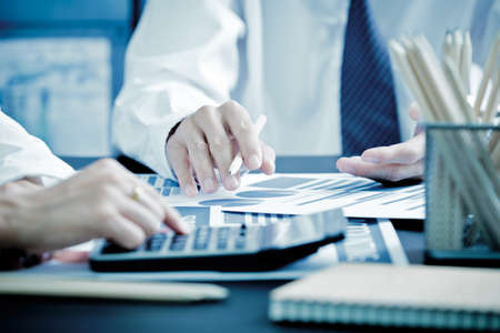 Business people discussing the charts and graphs showing the results of their successful teamwork