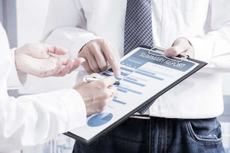 Business people discussing the charts and graphs showing the results of their successful teamwork