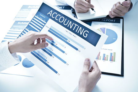 Business people discussing the charts and graphs showing the results of their successful teamworkの写真素材