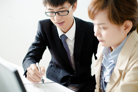 Business people discussing the charts and graphs showing the results of their successful teamworkの写真素材