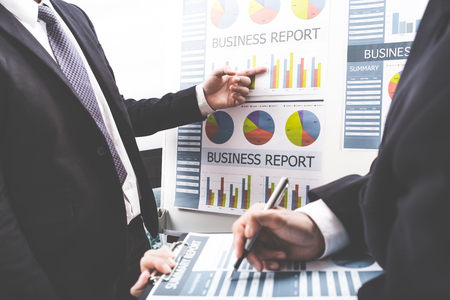 Business people discussing the charts and graphs showing the results of their successful teamworkの写真素材