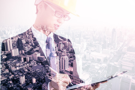 Double exposure of Architect sketching a construction project and city