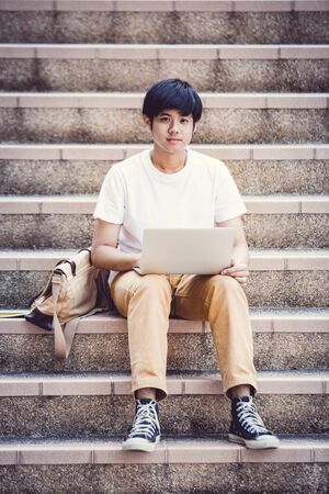 Smiling college student sitting on staircaseの写真素材