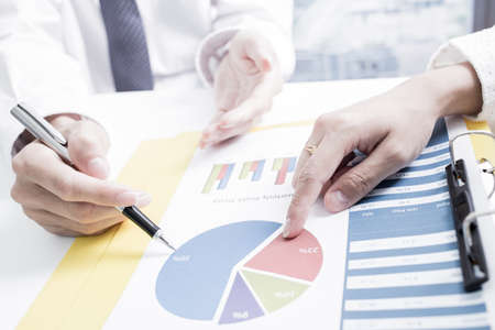 Business people discussing the charts and graphs showing the results of their successful teamwork