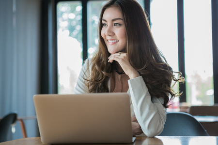Businesswoman drinking coffee / tea and using tablet computer in a coffee shopの写真素材