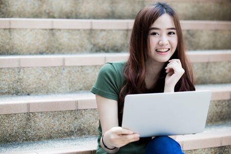 Smiling college student sitting on staircaseの写真素材