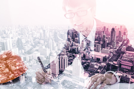 Double exposure of Architect sketching a construction project and cityの写真素材