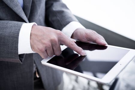 Young businessman working with modern devices, digital tablet computer and mobile phone.