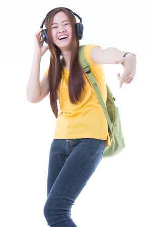 happy teen girl listening to music, full length, isolated on whiteの写真素材