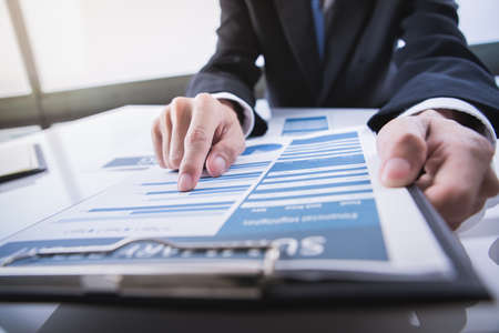 Business people discussing the charts and graphs showing the results of their successful teamworkの写真素材