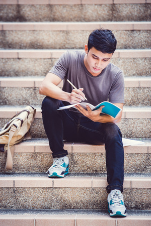 Smiling college student sitting on staircaseの写真素材