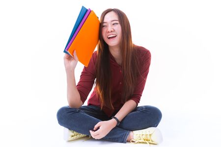 Young asian student girl with book. Isolated on white background.の写真素材