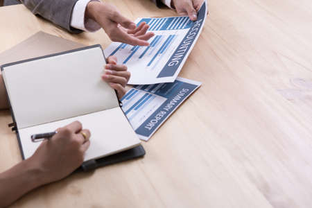 Business people discussing the charts and graphs showing the results of their successful teamworkの写真素材