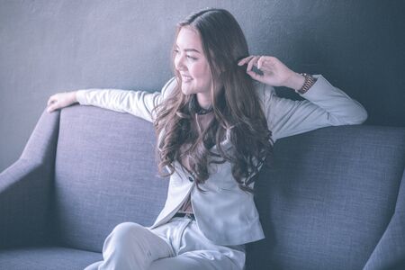 Portrait Of Businesswoman Sitting On Sofa In Modern Officeの写真素材