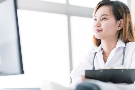 Portrait of a smiling physician working in her office. Asiaの写真素材