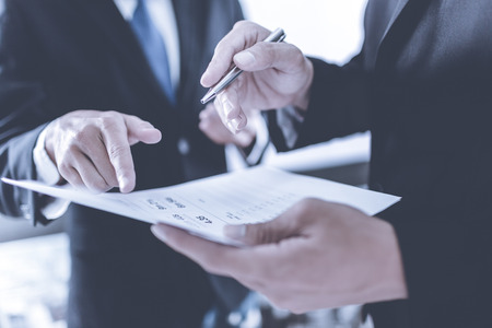 Business people discussing the charts and graphs showing the results of their successful teamworkの写真素材