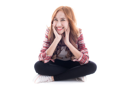 Young man sitting on the floor. Full length studio shot isolated on white. Asian male modelの写真素材