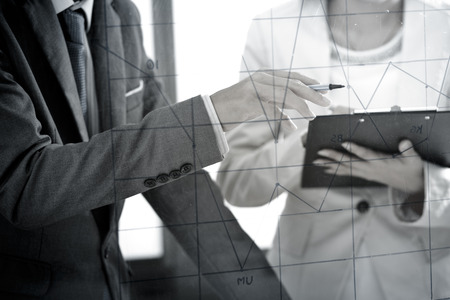 Business people discussing the charts and graphs showing the results of their successful teamworkの写真素材