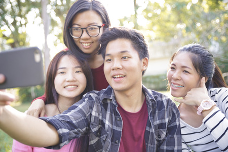 Group of Friends taking Self Portraits with Mobile Phoneの写真素材