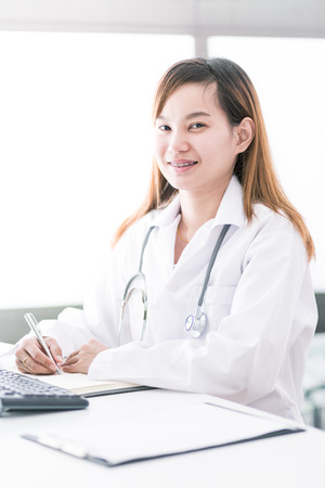 Portrait of a smiling physician working in her office. Asiaの写真素材