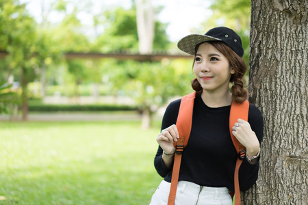 A female college student reading a book while lying on the parkの写真素材