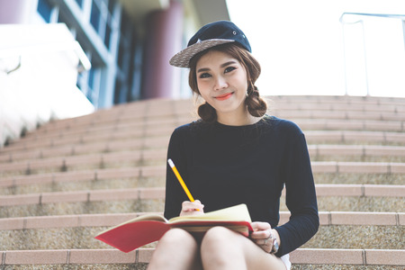 Smiling college student sitting on staircaseの写真素材