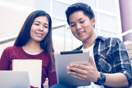 Two students studying with computer notebook outdoorsの写真素材