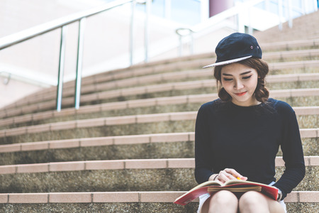 Smiling college student sitting on staircaseの写真素材