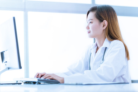 Portrait of a smiling physician working in her office. Asiaの写真素材