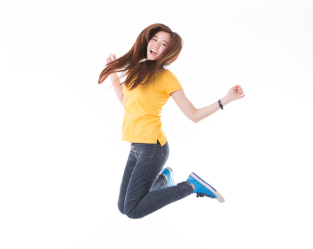 Jumping female college / university student isolated on white background. Young woman Asian Caucasian students.の写真素材