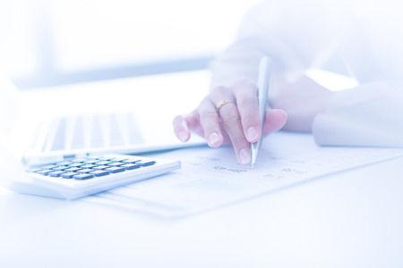 woman hand with pen and business reportの写真素材