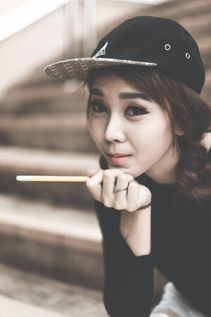 Smiling college student sitting on staircase and studying with booksの写真素材