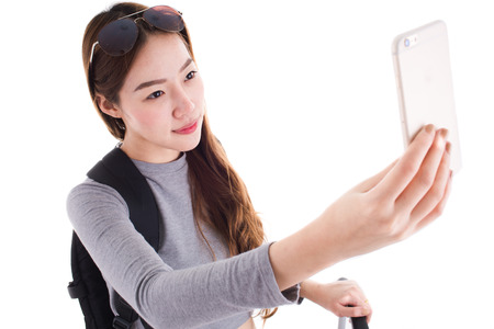 Asian woman with a suitcase on white background.の写真素材