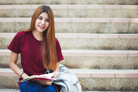 Smiling college student sitting on staircaseの写真素材